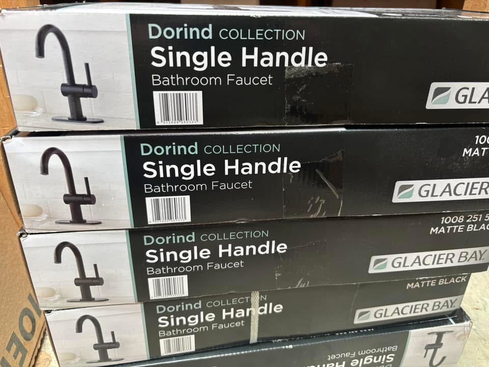Stack of boxed Glacier Bay Dorind single-handle matte black bathroom faucets